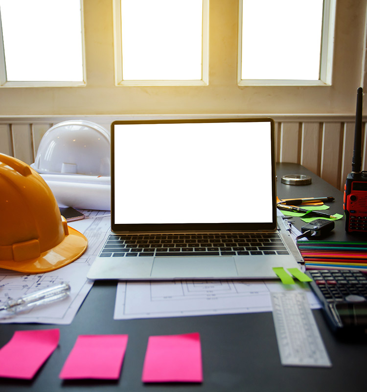 PC Arbeitsplatz mit Laptop, Haftnotizzetteln, Taschenrechner und Geschäftspapieren.